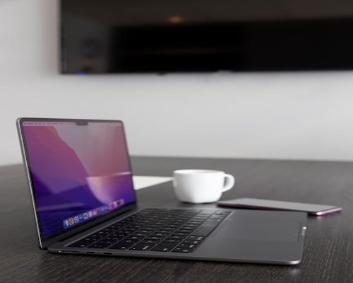 Closing a laptop at the end of a workday on a wooden table